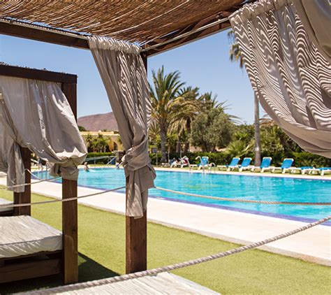 Zona de piscina con jacuzzi y tumbonas en Camping Los Escullos