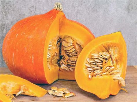 Calabaza butternut entera y cortada en trozos, rodeada de especias