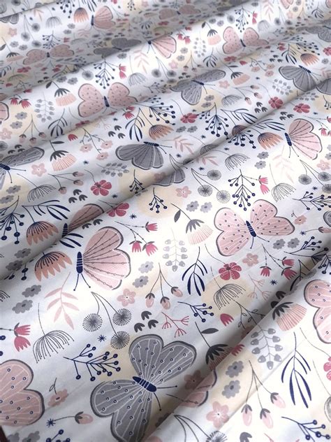 Tela con estampado de mariposas pastel sobre fondo verde