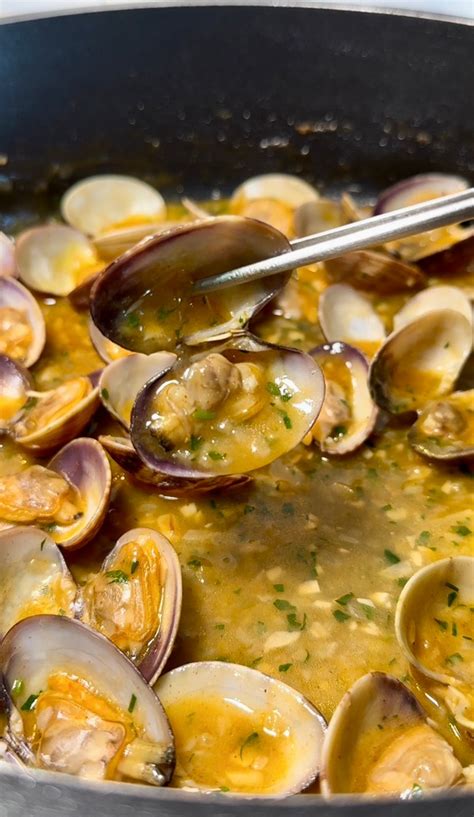 Almejas abriéndose en una olla con vino blanco