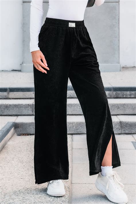 Mujer vistiendo pantalones de pana negros de tiro alto con pernera ancha