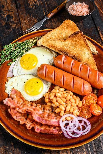 Plato de desayuno inglés completo con huevos, tocino, salchichas y frijoles