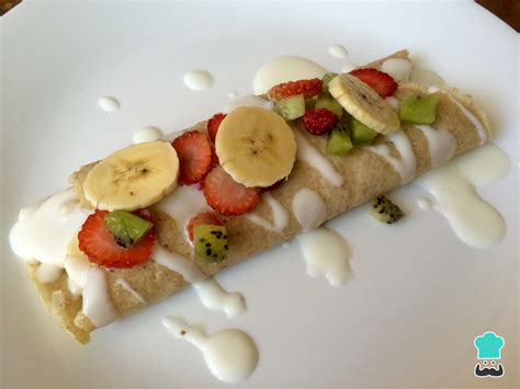 Crepes rellenos de yogur y frutas rojas, decorados con más fruta.