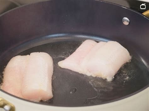 Sartén con lomos de merluza friéndose en aceite dorado
