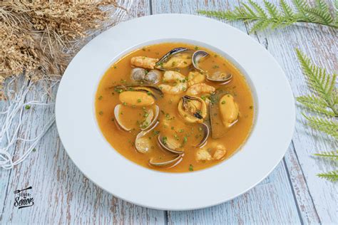 Mesa navideña con sopa de marisco como plato principal