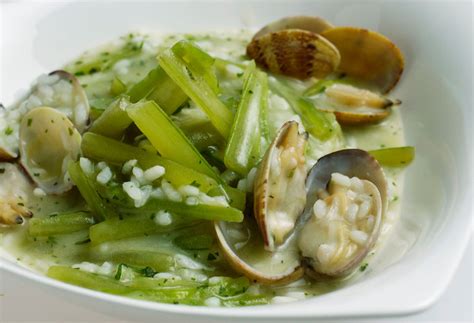 Plato de arroz con borrajas y almejas servido en restaurante