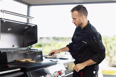 Fotografía de Rubén cocinando en una barbacoa Weber en un ambiente festivo
