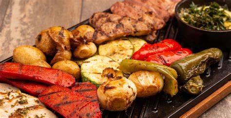 Mesa de restaurante con una parrillada abundante y guarniciones