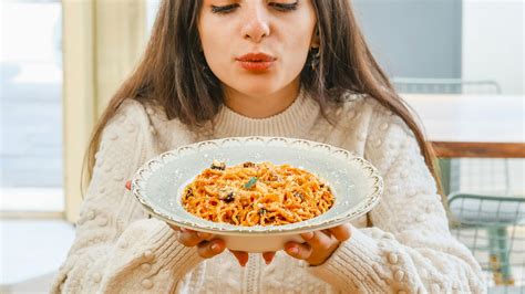 Mujer disfrutando un plato de pasta sin culpa