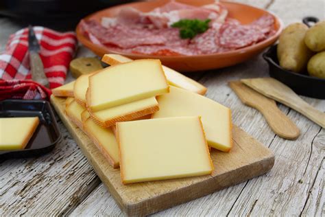 Queso raclette en una rueda grande listo para ser derretido