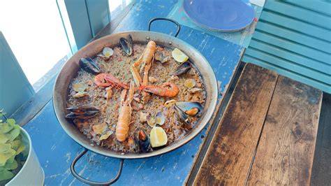 Detalle de una paella marinera servida en la mesa