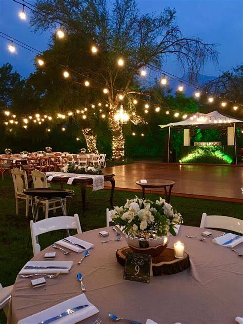 Diseño de mesas al aire libre con decoración rústica y luces cálidas para una fiesta postboda