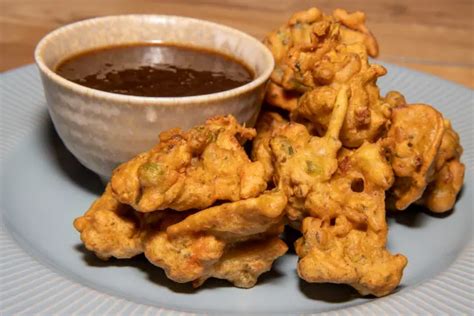 pakoras doradas y crujientes servidas en un plato con salsa