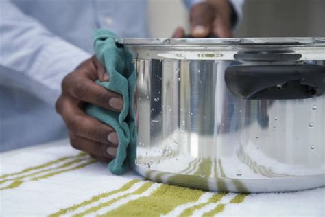 Persona limpiando una olla quemada