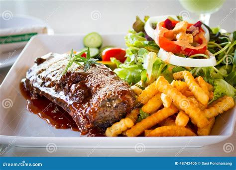 Costillas adobadas con patatas y ensalada