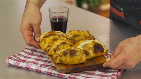 Mesa con provoleta y empanadas en La Emilia