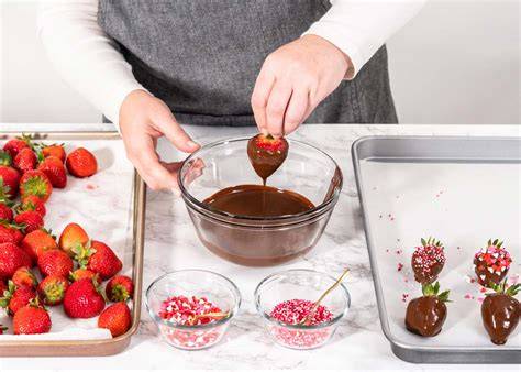 Proceso de baño de fresas en chocolate