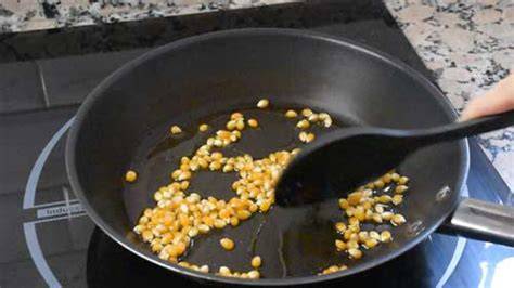 Sartén con palomitas de maíz explotando en la estufa