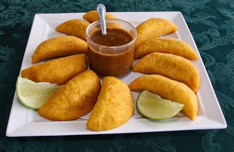 Plato de arepas y empanadas colombianas con salsa fresca