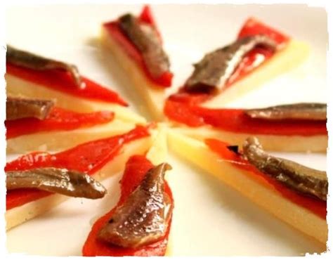 Tapa de queso manchego con anchoas y tomate