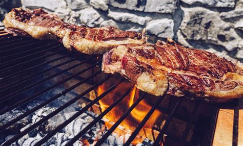 Persona apagando las brasas de una barbacoa con agua