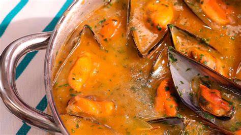 Mejillones cocinándose en una cazuela con vino blanco y perejil