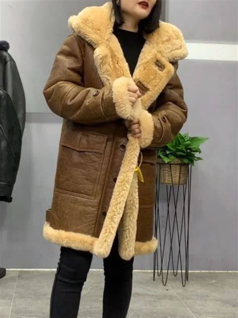 Hombre usando un abrigo de piel de oveja en un paisaje invernal