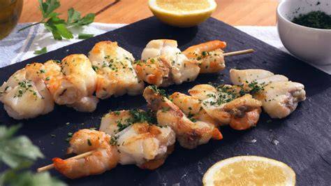 Brochetas de rape cocinándose en la plancha