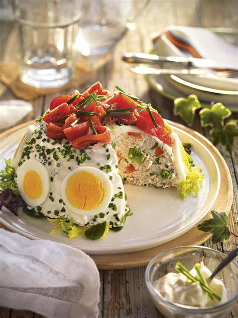 Ensaladilla rusa decorada con pimientos y huevo