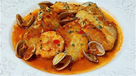 Selección de ingredientes frescos: merluza, gambas, almejas, ajo y tomate