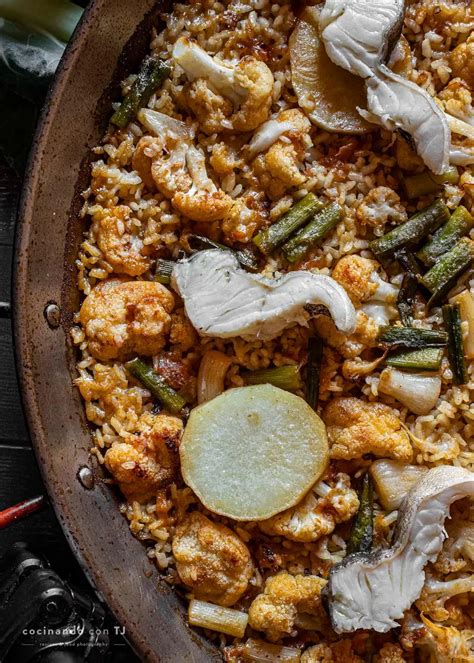 Mujeres cocinando paella de cebolla y bacalao en un evento tradicional