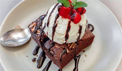 Brownie con helado y frutas