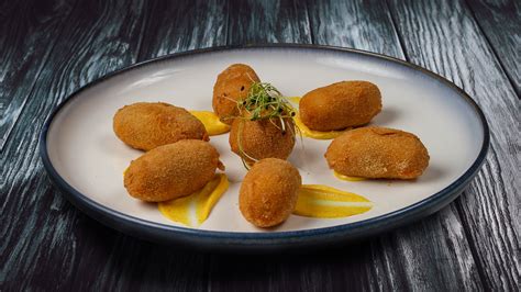 Plato de croquetas de parmesano recién hechas y crujientes