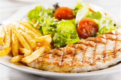 Plato de churrascos de pollo con alioli, patatas fritas y ensalada