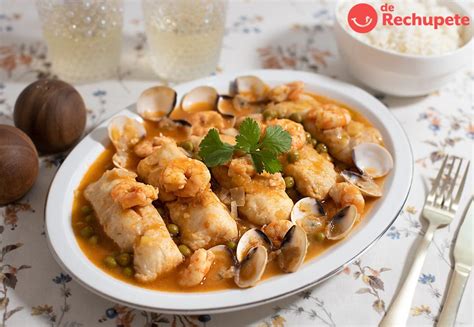 Plato de merluza a la sidra decorado con perejil y almejas