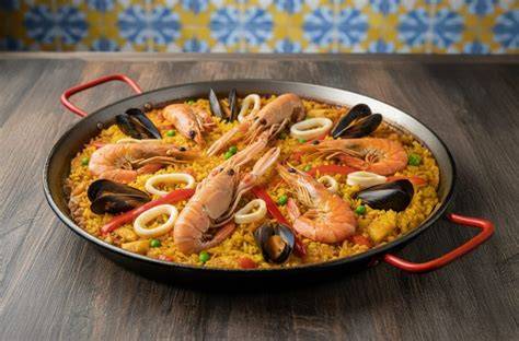 Paella de marisco decorada con gotas de alioli de ajo negro