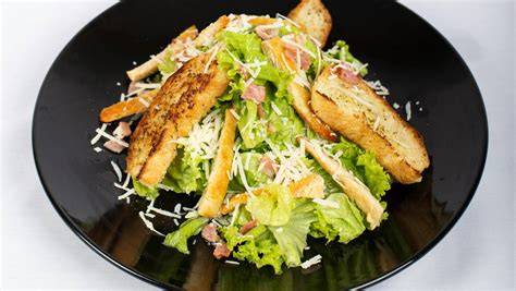 Presentación artística de una ensalada gourmet en fuente grande
