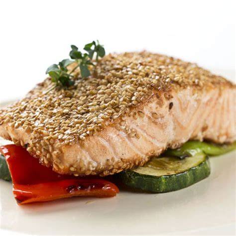 Plato de salmón a la naranja decorado con sésamo y guarnición de verduras