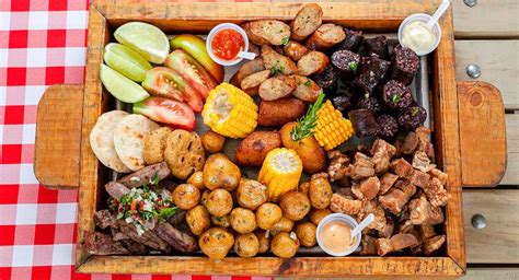 Tabla de picada colombiana con diversas carnes y acompañamientos