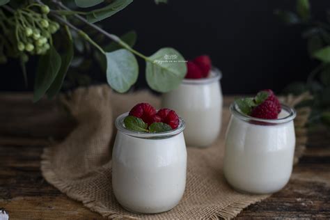 Vasitos de mousse de leche condensada decorados con frambuesas y hierbabuena