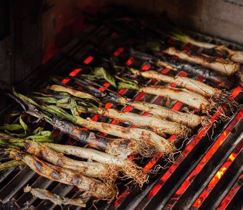Calçots asándose en una parrilla de carbón