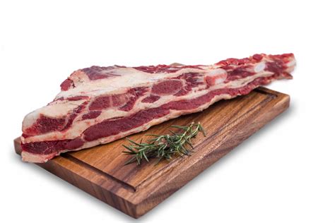Corte de carne de falda de cordero cruda sobre tabla de madera