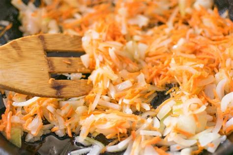 Cebolla y zanahoria sofritas en una sartén