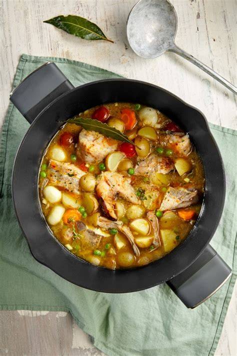 Gallo cocinándose en una cazuela con verduras