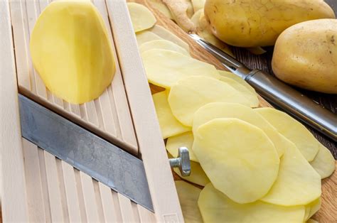 Mandolina cortando patatas en rodajas finas