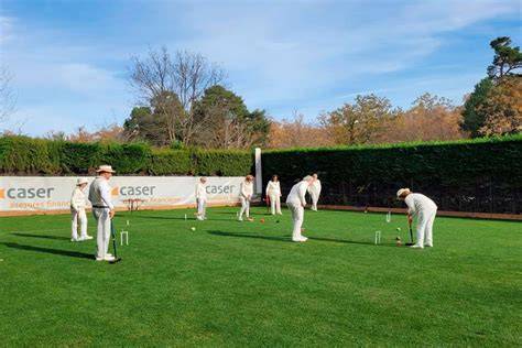 Campo de croquet profesional con jugadores en plena competición