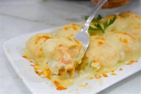 Plato de huevos rellenos gratinados con gambas decorados con perejil