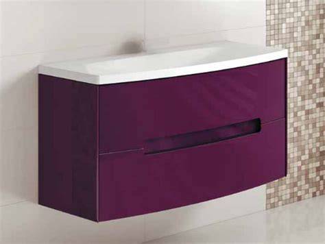 Cuarto de baño amplio con mueble suspendido color berenjena y paredes blancas
