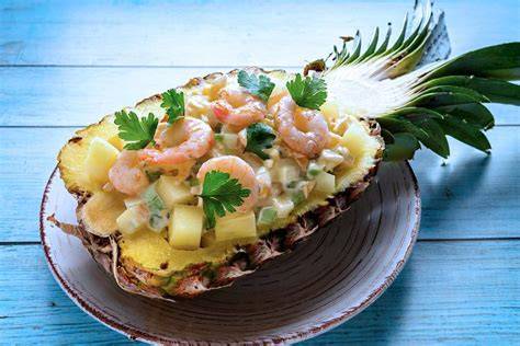 Plato de cóctel de camarones con piña decorado con cilantro