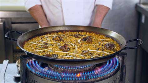 Primer plano de la paella de pato de l'Albufera con alcachofas